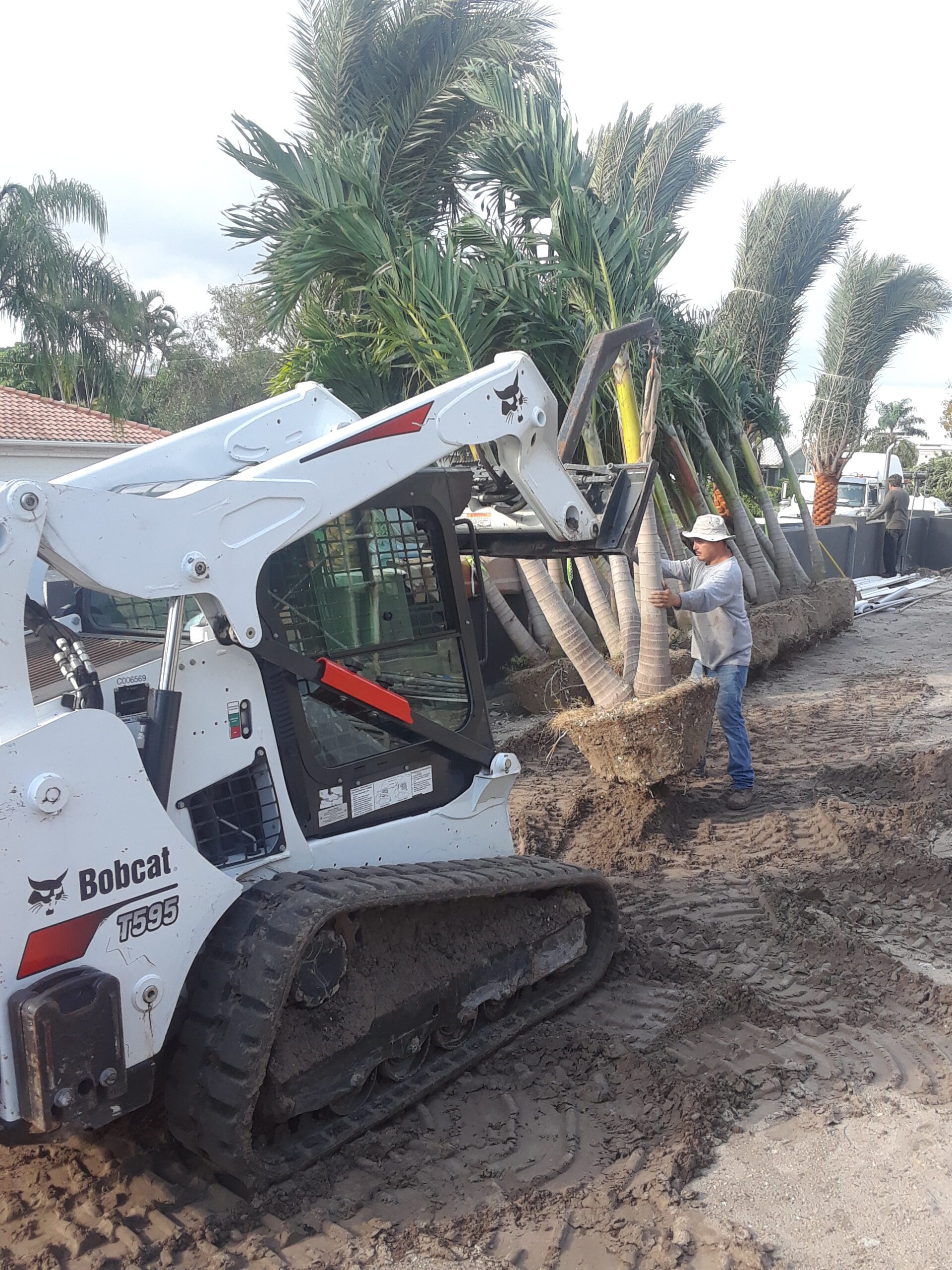 A Person Standing In Dirt Next To A White Machine