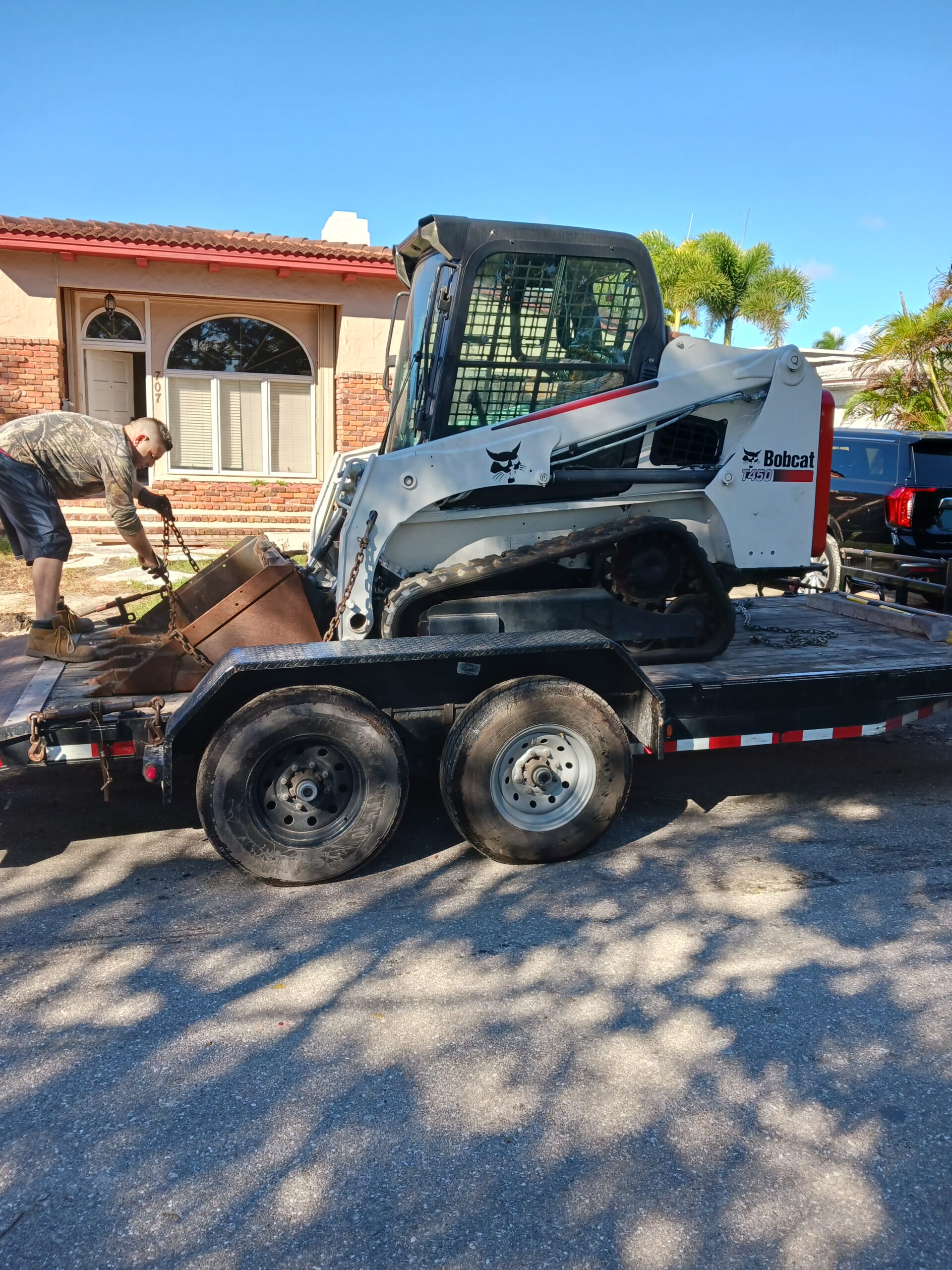 A Person Loading A Heavy Machine Into A Trailer
